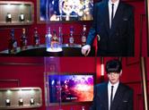 吴亦凡身穿黑色西装，系着领带一头齐刘海十分惹眼。