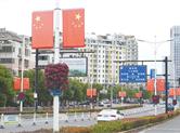 新昌县城区部分道路两旁的路灯上开始悬挂红旗，喜迎国庆佳节